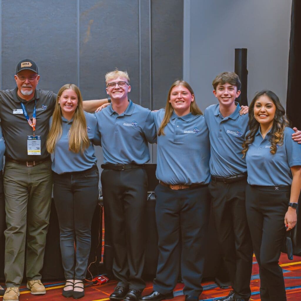 Group of students and mentor standing together and smiling